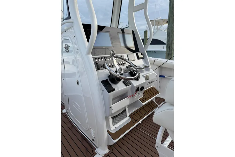 Slide: The Image of 2024 Tidewater 272 LXF boat console with steering wheel and controls, featuring modern design. - 17