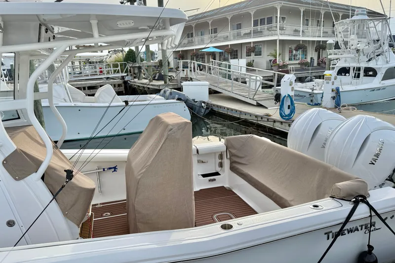 Slide: The Image of 2024 Tidewater 272 LXF boat docked, featuring covered seating and twin Yamaha engines. - 23