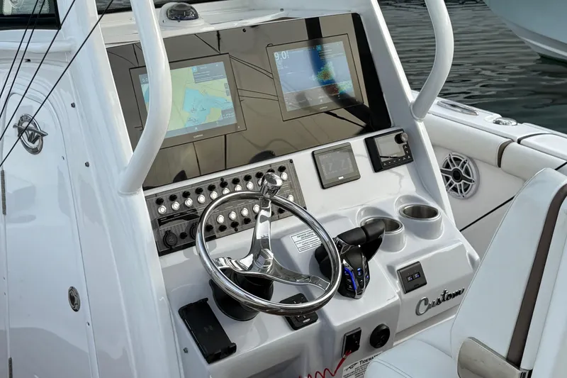 Slide: The Image of 2024 Tidewater 272 LXF boat dashboard with dual navigation screens and steering wheel. - 3