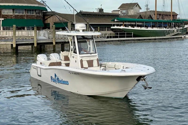 Slide: The Image of 2024 Tidewater 272 LXF boat docked in a marina, featuring dual engines and sleek design. - 6