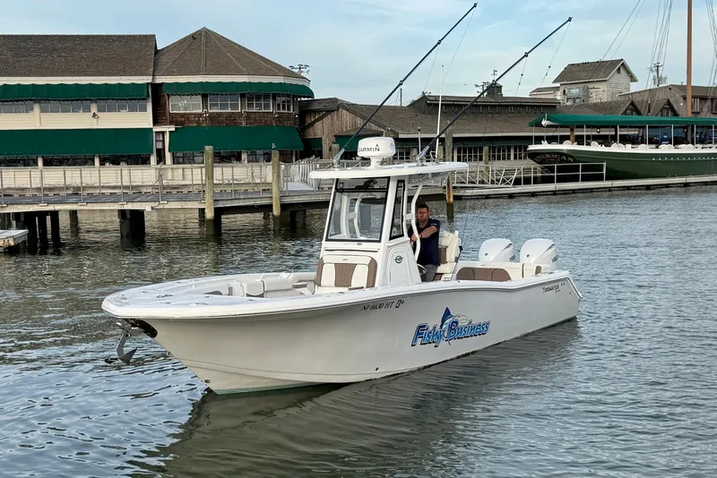 Slide: The Image of 2024 Tidewater 272 LXF boat docked near waterfront buildings. - 8