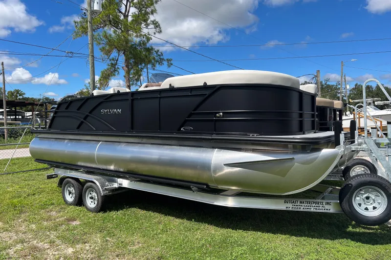 The Image of 2026 Sylvan Mirage 822 CLZ pontoon boat on trailer, parked outdoors under blue sky. - 1
