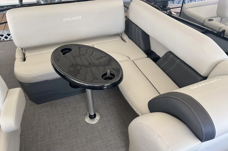 Slide: The Image of 2026 Sylvan Mirage 822 CLZ boat interior with plush seating and sleek table design. - 12