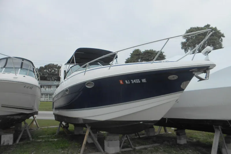 Slide: The Image of 2004 Formula 27 Performance Cruiser boat on stands, blue and white hull, outdoor storage. - 28
