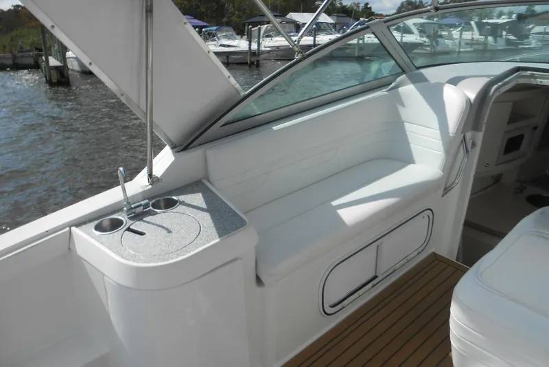 Slide: The Image of 2004 Formula 27 Performance Cruiser interior with seating and sink, docked by the water. - 6