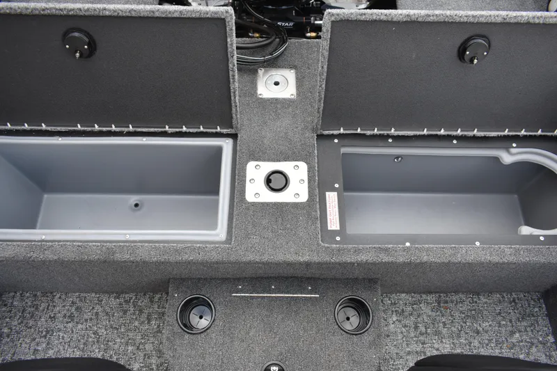 Slide: The Image of 2026 Tracker Targa V-19 WT boat storage compartments with carpeted interior and cup holders. - 102