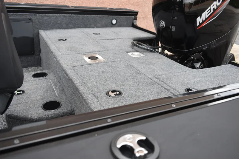 Slide: The Image of 2026 Tracker Targa V-19 WT boat interior with carpeted deck and Mercury engine. - 87