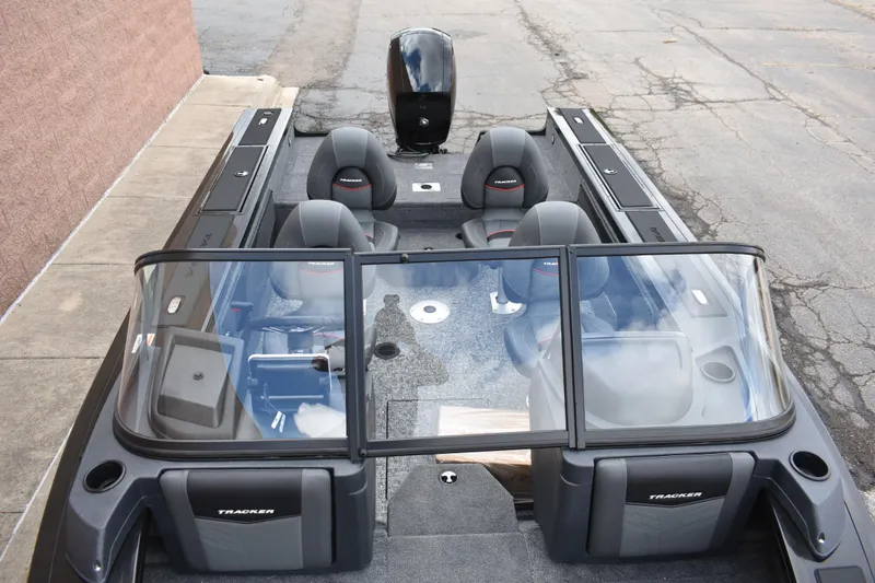 Slide: The Image of 2026 Tracker Targa V-19 WT boat interior with seating and windshield, parked on pavement. - 96