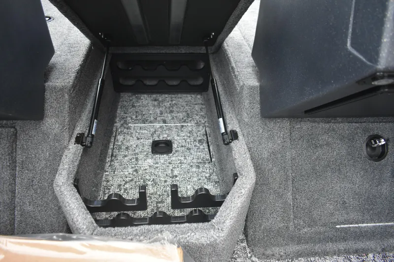 Slide: The Image of 2026 Tracker Targa V-19 WT interior storage compartment with carpeted finish and rod holders. - 97