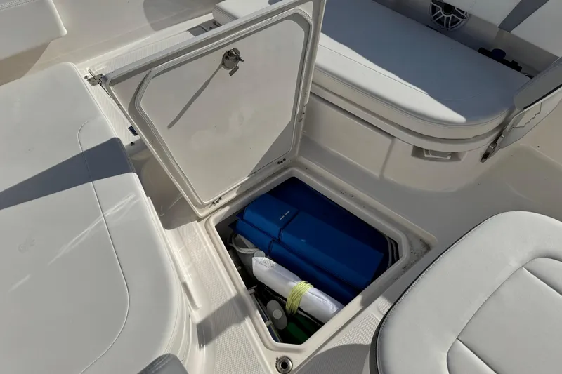 Slide: The Image of Open storage compartment on 2023 Robalo 266 Cayman boat, showing interior equipment. - 15