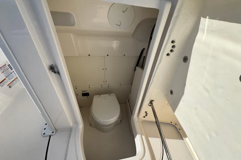 Slide: The Image of 2023 Robalo 266 Cayman boat interior with compact marine toilet. - 17