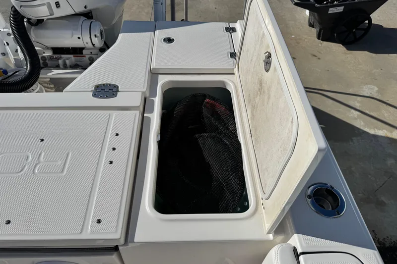 Slide: The Image of 2023 Robalo 266 Cayman boat storage compartment with open lid, showcasing interior space. - 25
