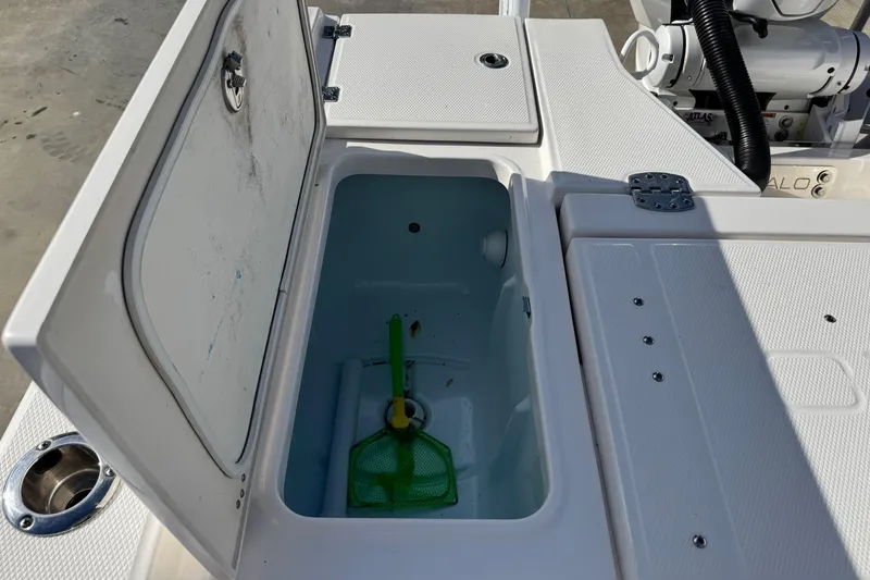 Slide: The Image of Open storage compartment on 2023 Robalo 266 Cayman boat, featuring a green net inside. - 26