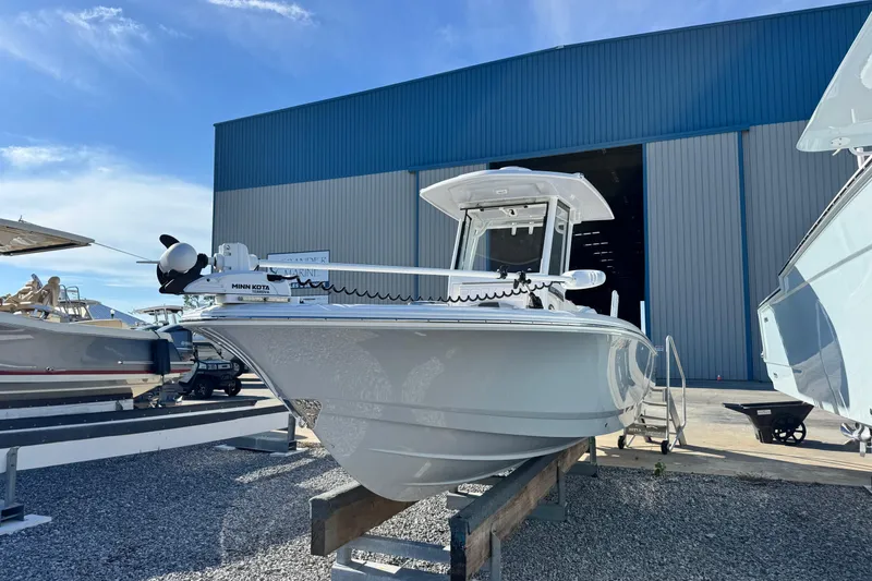 Slide: The Image of 2023 Robalo 266 Cayman boat displayed outdoors near a large blue warehouse. - 4
