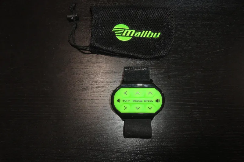 Slide: The Image of Green Malibu Wakesetter 24 MXZ 2018 control device with black mesh pouch on dark surface. - 14