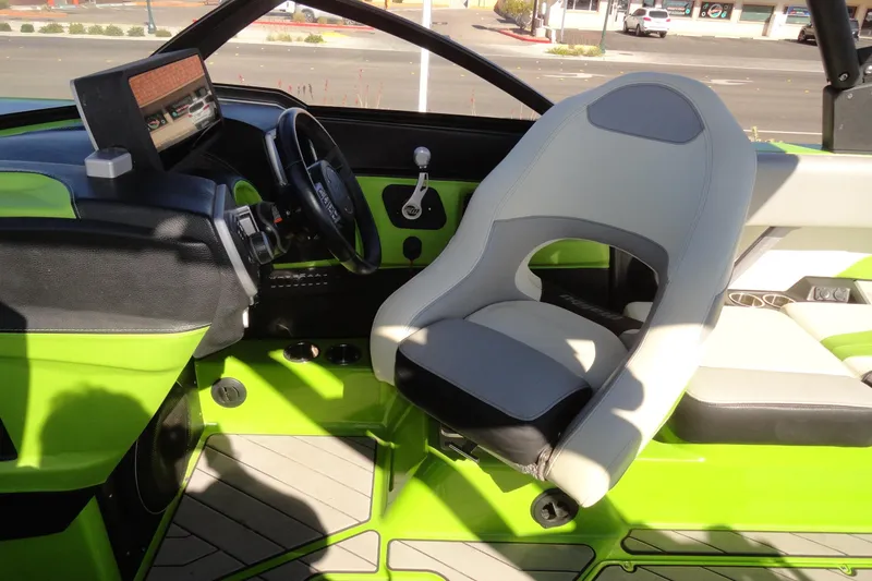 Slide: The Image of 2018 Malibu Wakesetter 24 MXZ boat interior with green accents and modern dashboard. - 15