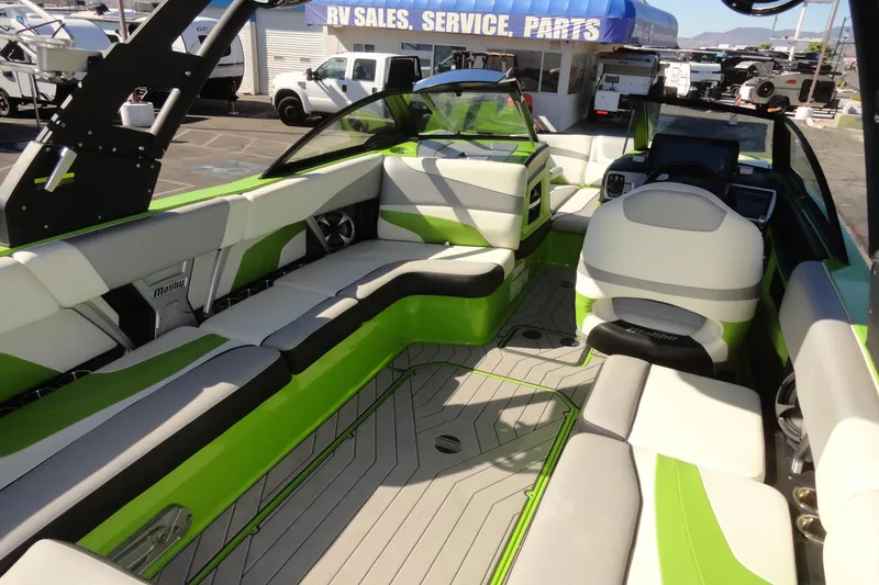 Slide: The Image of 2018 Malibu Wakesetter 24 MXZ interior with green and white seating, parked at dealership. - 18