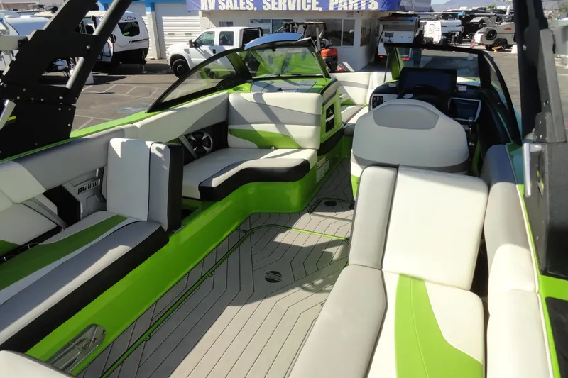 Slide: The Image of 2018 Malibu Wakesetter 24 MXZ boat interior with green and white seating. - 19