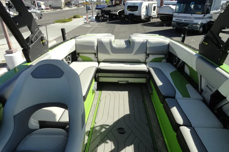 Slide: The Image of 2018 Malibu Wakesetter 24 MXZ boat interior with green and gray seating. - 23