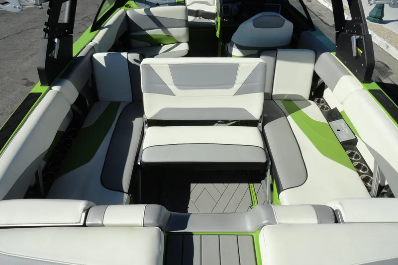 Slide: The Image of 2018 Malibu Wakesetter 24 MXZ interior with green and gray seating arrangement. - 25
