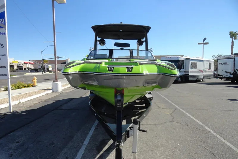 Slide: The Image of 2018 Malibu Wakesetter 24 MXZ in vibrant green on a trailer, parked outdoors. - 3