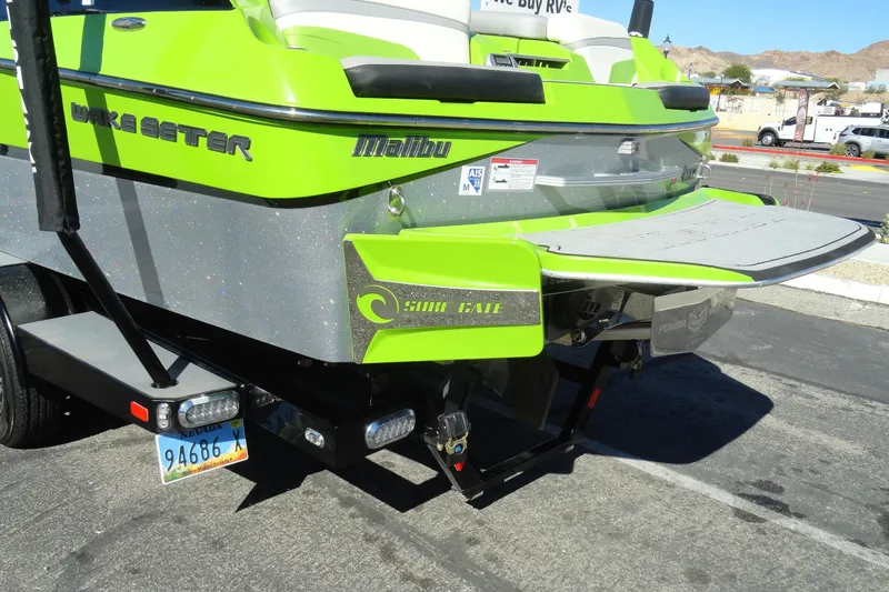 Slide: The Image of 2018 Malibu Wakesetter 24 MXZ boat with vibrant green detailing and swim platform. - 6
