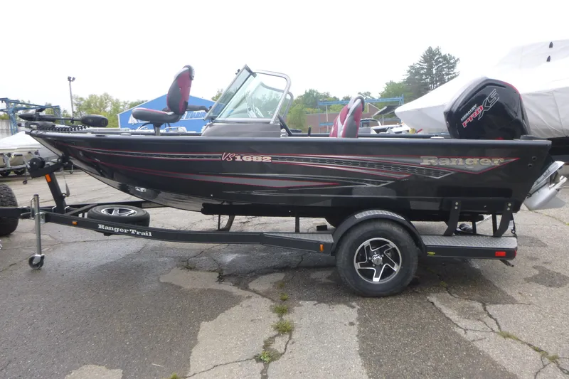 Slide: The Image of 2020 Ranger VS1682 WT fishing boat on trailer, black with red accents, parked outdoors. - 4