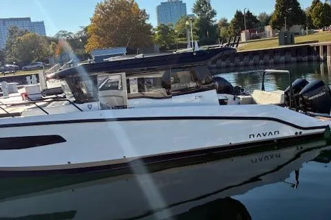 Slide: The Image of 2025 Navan C30 boat docked in a marina with trees and buildings in the background. - 9
