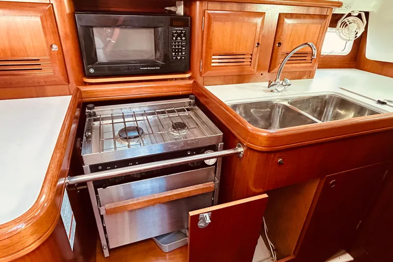 Slide: The Image of 2001 Beneteau 411 yacht kitchen with stove, microwave, and double sink. - 13