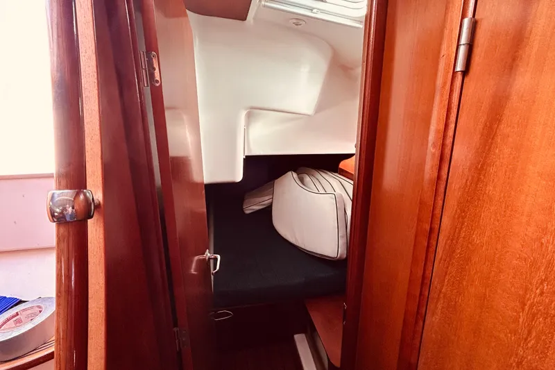 Slide: The Image of Interior cabin of 2001 Beneteau 411 sailboat with wooden finish and cushions. - 17