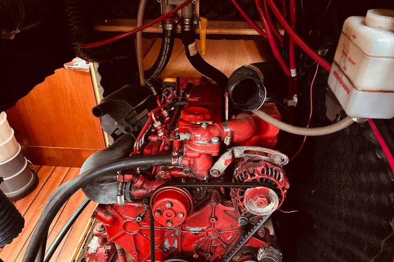 Slide: The Image of Engine compartment of a 2001 Beneteau 411 sailboat, featuring a red engine. - 23