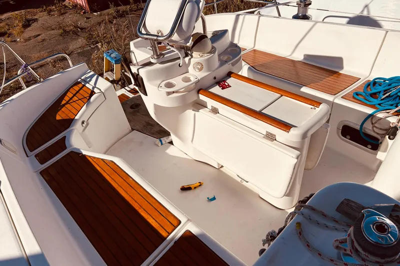 Slide: The Image of Cockpit of 2001 Beneteau 411 sailboat with wooden seating and nautical equipment. - 29