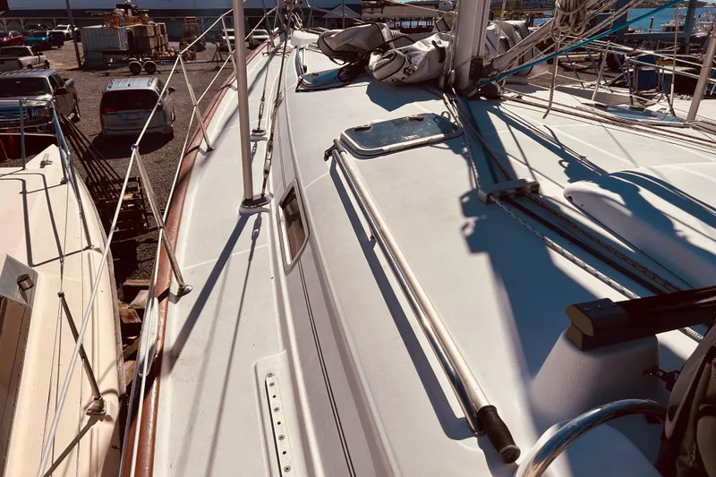 Slide: The Image of Deck view of a 2001 Beneteau 411 sailboat in a marina setting. - 30