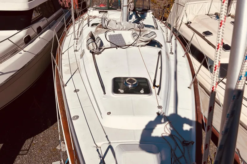 Slide: The Image of 2001 Beneteau 411 sailboat deck view, docked between other boats. - 31