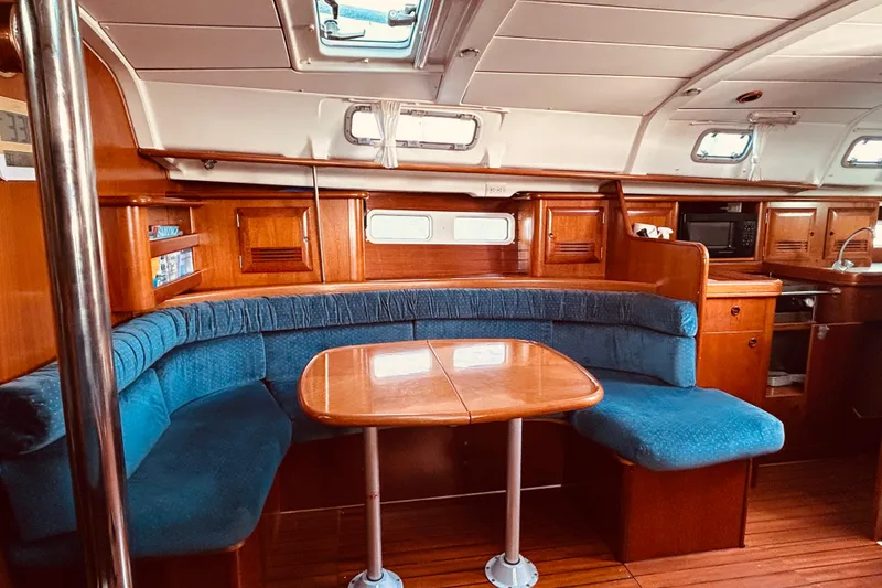Slide: The Image of Interior of 2001 Beneteau 411 yacht with wooden furnishings and blue seating. - 4