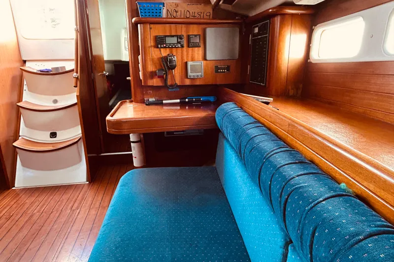 Slide: The Image of Interior of 2001 Beneteau 411 sailboat with wooden finish and blue seating. - 6