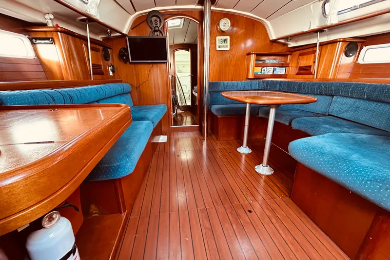 Slide: The Image of Interior of 2001 Beneteau 411 sailboat with wood finish and blue seating. - 7