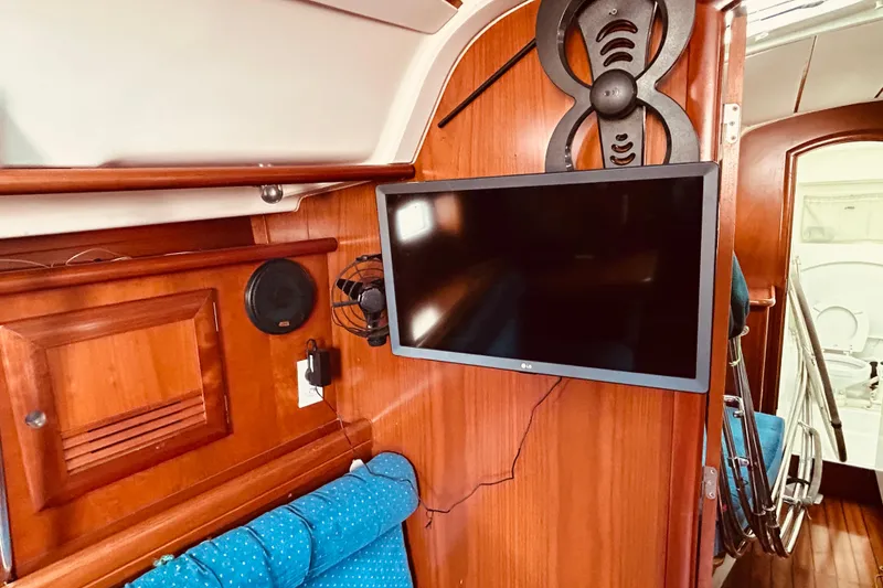 Slide: The Image of Interior of 2001 Beneteau 411 yacht with mounted TV and wooden cabinetry. - 8