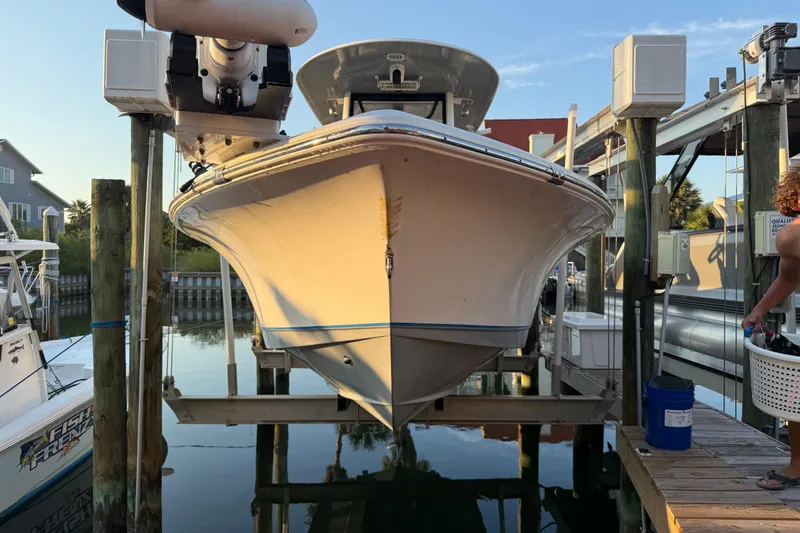 Slide: The Image of 2018 Sea Hunt BX 25 FS boat docked on a lift at a marina. - 1