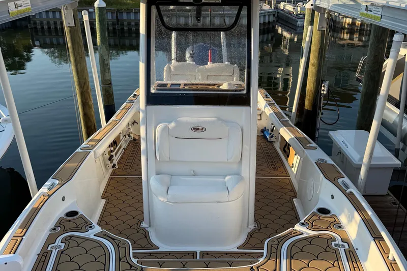 Slide: The Image of 2018 Sea Hunt BX 25 FS boat interior with custom flooring, docked at marina. - 10