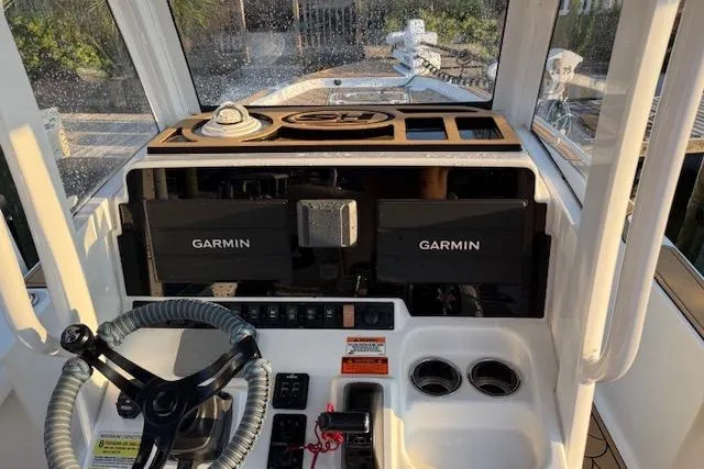 Slide: The Image of 2018 Sea Hunt BX 25 FS boat dashboard with Garmin navigation systems and steering wheel. - 11