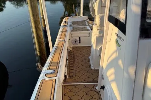 Slide: The Image of 2018 Sea Hunt BX 25 FS boat deck with custom flooring, docked by calm water. - 5