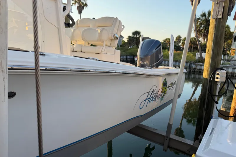 Slide: The Image of 2018 Sea Hunt BX 25 FS boat docked, featuring a powerful outboard motor. - 7