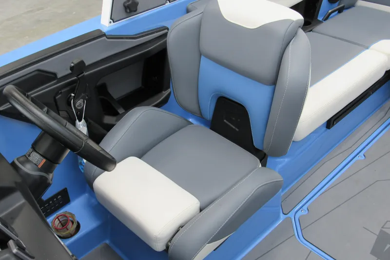 Slide: The Image of 2024 Axis T220 boat interior with gray and blue seating, steering wheel, and controls. - 11
