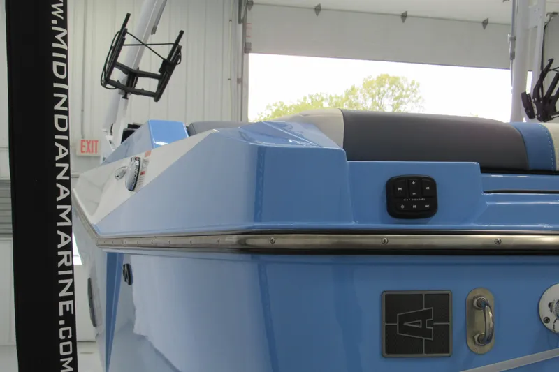 Slide: The Image of 2024 Axis T220 boat in showroom, featuring sleek blue design and control panel. - 13