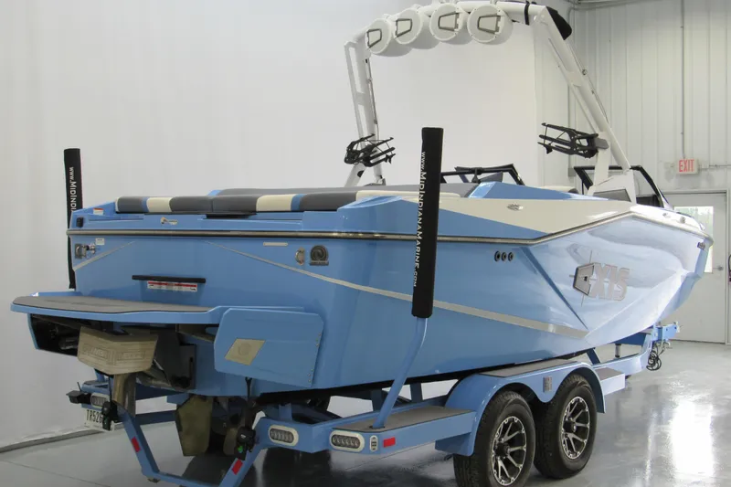 Slide: The Image of 2024 Axis T220 boat in light blue, displayed indoors on a trailer. - 2
