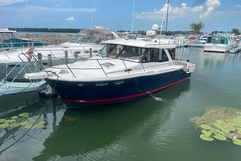 Slide: The Image of 2022 Cutwater C-30 Sedan docked in a marina, surrounded by other boats. - 1