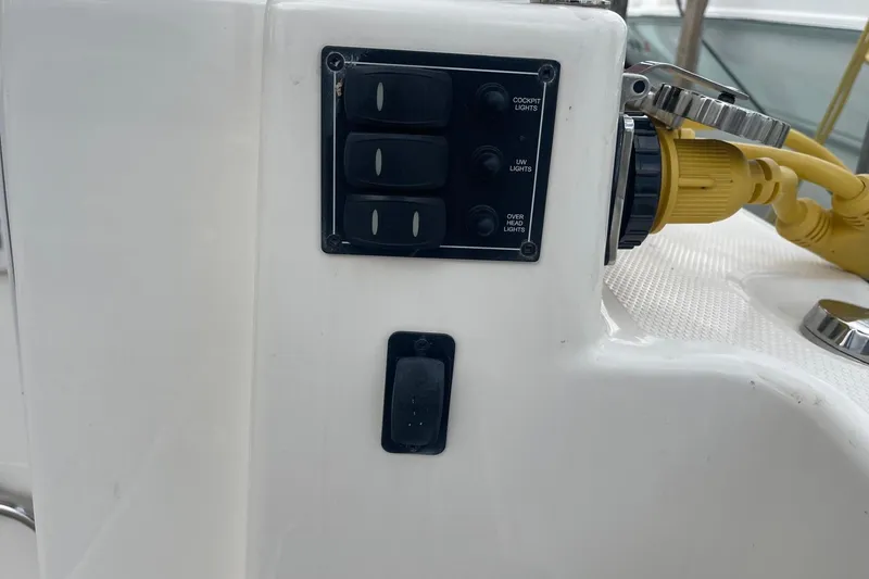 Slide: The Image of Control panel on 2022 Cutwater C-30 Sedan boat with light switches and power connection. - 10