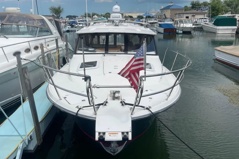 Slide: The Image of 2022 Cutwater C-30 Sedan docked in marina, American flag displayed on bow. - 2