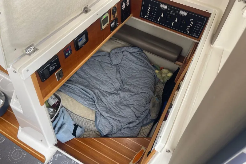 Slide: The Image of 2022 Cutwater C-30 Sedan interior cabin with cozy bedding and control panels. - 22